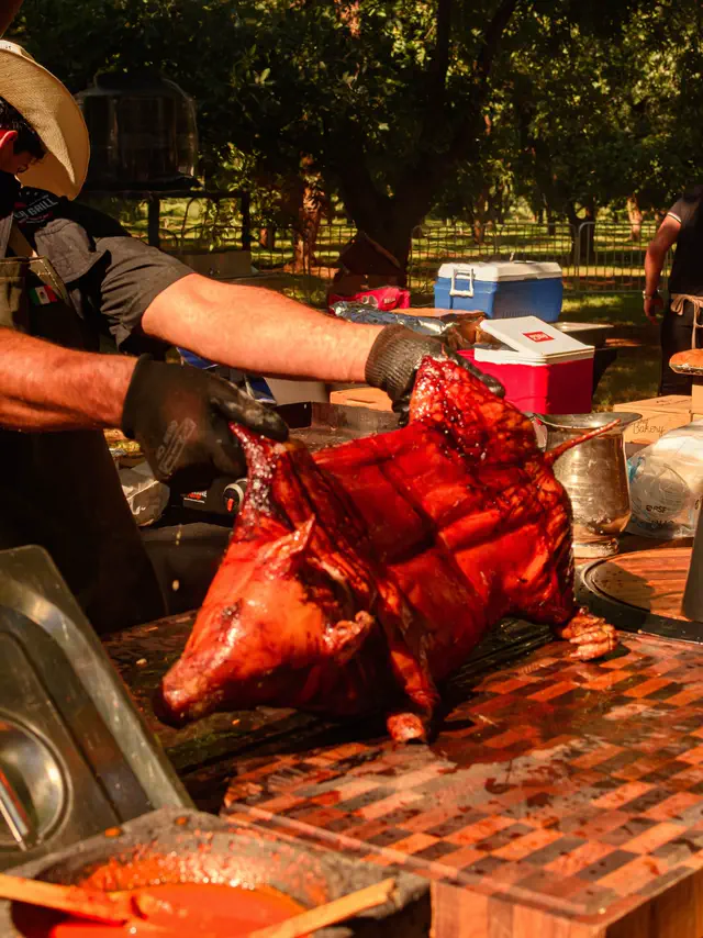 Un cerdo entero recién sacado del asador, listo para porcionarse al aire libre