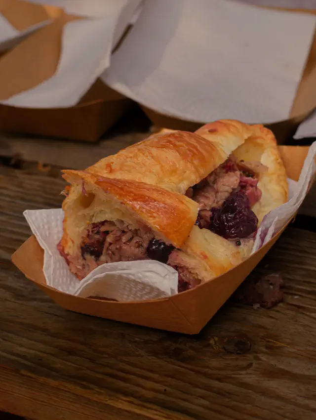 Pan hojaldrado relleno de carne y frutos rojos, servido en charola